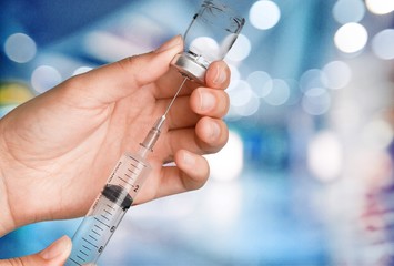 Human Hand with injection Syringe on light background