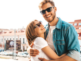 Portrait of smiling beautiful girl and her handsome boyfriend. Woman in casual summer jeans clothes. Happy cheerful family. Female having fun on the street background in sunglasses