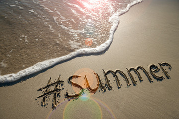 Modern message for summer with a social media-friendly hashtag written in smooth sand with incoming...