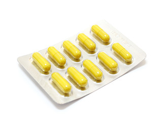 Medicine yellow pills on white background with copy space