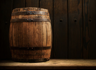 Wooden barrel and glass of beer on a old oak table of wood.