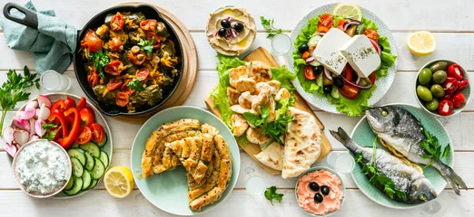 Papier Peint photo Manger Sélection de plats grecs traditionnels - salade, meze, tarte, poisson, tzatziki, dolma sur fond de bois, vue de dessus