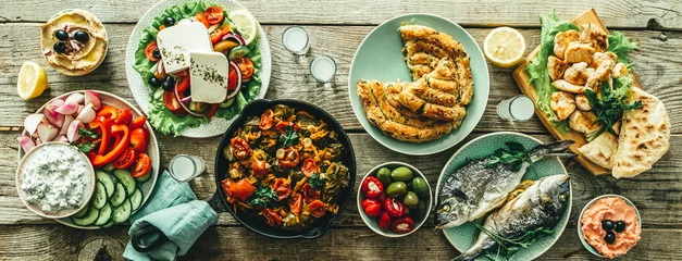 Tuinposter Eten Selectie van traditioneel Grieks eten - salade, meze, taart, vis, tzatziki, dolma op houtachtergrond, bovenaanzicht
