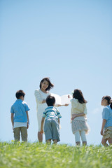 Obraz premium Uczniowie i nauczyciele szkół podstawowych uczący się w plenerze