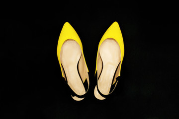 Yellow-black summer shoes on black background.Luxury Party shoes. Minimal fashionable concep. Fashion accessories. Summer outfit