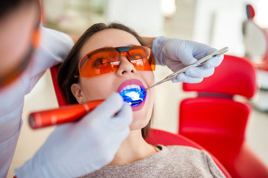 Treatment of light seal beautiful girl in dentistry.