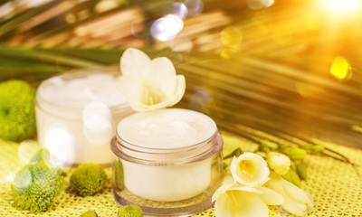 Cosmetic cream with white flowers on  table