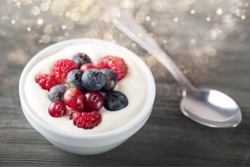 Yogurt with forest berries  on wooden table