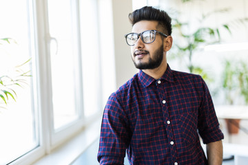 Happy Indian business man in glasses at the office.