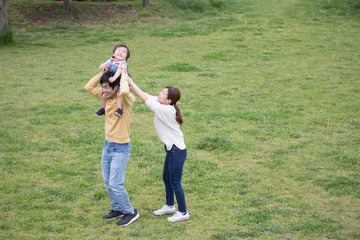 Obraz premium 公園で肩車する若い父親、育児イメージ