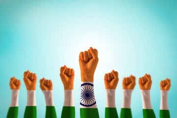 India national flag pattern on leader's fist isolated (clipping path) on blue mint sky for Human...