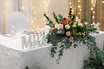 Main table at a wedding decorated with flowers and a Mr & Mrs sign