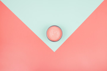 An elevated view of paint can on mint and coral background