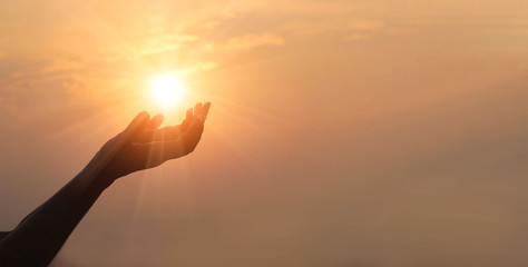 Woman hands praying for blessing from god on sunset background