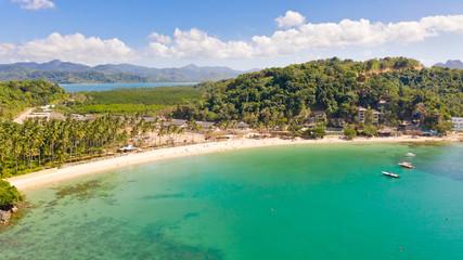 Las Cabanas Beach. Islands and beaches of El Nido.Tropical islands with white sandy beaches, aerial view.Tourists relax on the white beach.