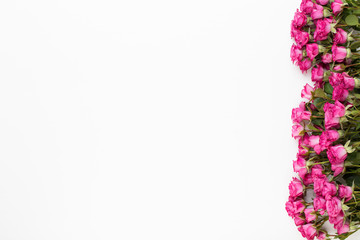 Flowers composition. Frame made of red rose on white wooden background. Flat lay, top view, copy space.