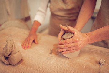 Obraz na płótnie Canvas Close up of male hands making a pot