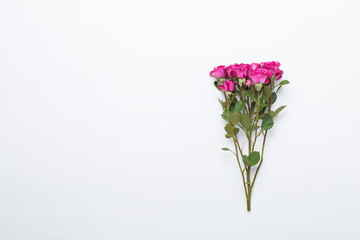 Flowers composition. Frame made of red rose on white wooden background. Flat lay, top view, copy space.
