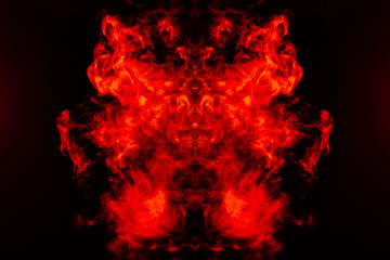 Smoke of different orange and red colors in the form of horror in the shape of the head, face and eye with wings on a black isolated background. Soul and ghost in mystical symbol