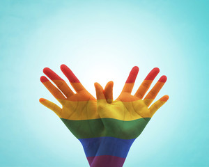 Rainbow flag pattern on people's hand in butterfly shape for Zero discrimination day concept