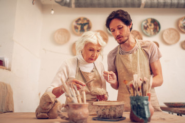 Pleasant creative people speaking about clay work