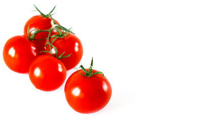 Red juicy cherry tomatoes with green tails lying on a white background