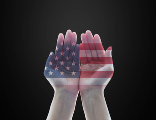 America flag pattern on woman's hands with open palms on black background for USA public holiday remembrance concept....