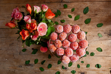 Arrangement of peaches shaped homemade cookies with flower on the vintage background.