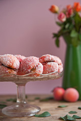 Arrangement of peaches shaped homemade cookies with flower on the vintage background.