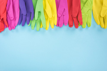 multicolored rubber gloves on blue background with copy space