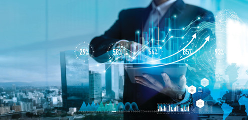 Digital marketing. Business strategy. Businessman using tablet analyzing sales data and economic...