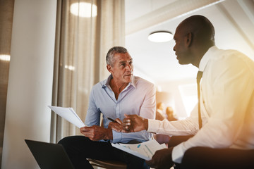 Two diverse businessmen going over documents together in an offi