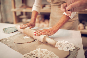 Close up of a rolling pin in female hands