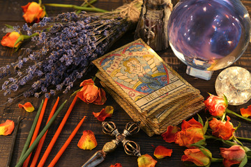 Tarot cards with magic crystal ball, candles and lavender flowers.
