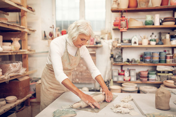 Pleasant aged woman looking at her work