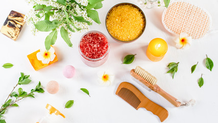 Spa and bath accessories with bath salts and beauty treatment products on white table. Wellness concept