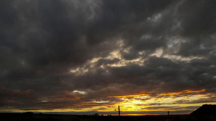 Fundo escuro com pôr-do-sol e núvens negras