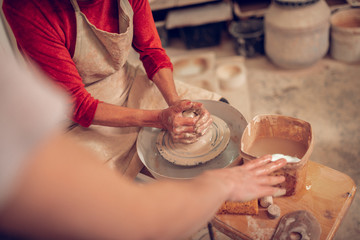 Nice pleasant woman sitting near the pottery wheel