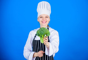 Natural wholesome food for a healthy lifestyle. Lady cook smiling with natural green broccoli in hand. Happy woman chef holding natural cabbage. Healthy choice of fresh raw natural broccoli plant