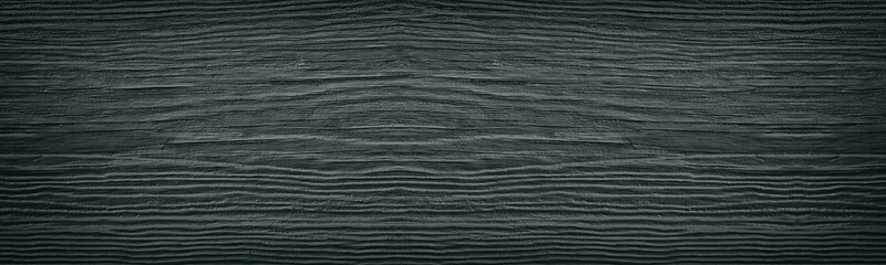 Old cracked black painted solid wooden surface wide texture. Dark gray wood panoramic retro background