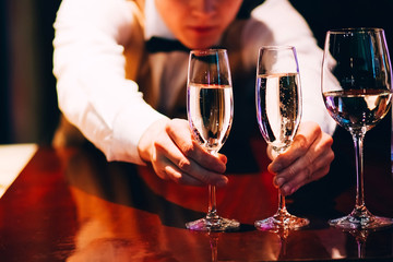 the bartender pours champagne. waiter pouring champagne at a party.