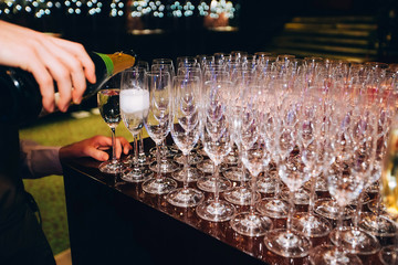 the bartender pours champagne. waiter pouring champagne at a party.