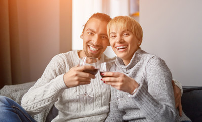 Couple with wine looking at camera