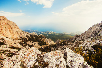 mountain landscape in the sun. mighty mountains. view from the mountains to the sea. rocky mountains and blue sky. Clouds hanging over the mountains.
