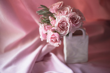 A small bouquet of pink roses.Wedding floristry. Delicate pastel colors. Vase bag