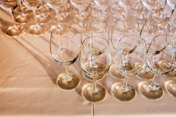 many empty champagne glasses close up. glass goblets on the white table. Empty crystal wineglass. glass goblet on a high leg.