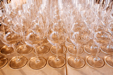 many empty champagne glasses close up. glass goblets on the white table. Empty crystal wine glass. glass goblet on a high leg.