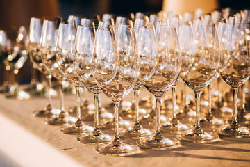 many empty champagne glasses close up. glass goblets on the white table. Empty crystal wineglass. glass goblet on a high leg.