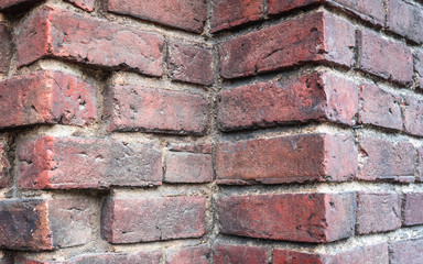 Bricks texture. Dark red brick wall. Corner of old brick building. Colorful red and brown brick wall background.