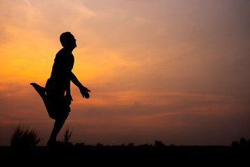 Fototapeta na wymiar Man running alone at beautiful sunset in the road at park . Summer sport and freedom concept. Athlete training on dusk. - Image